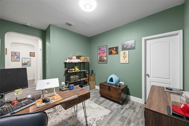 home office featuring wood-type flooring and a textured ceiling