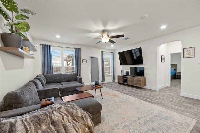 living room with ceiling fan and light hardwood / wood-style flooring