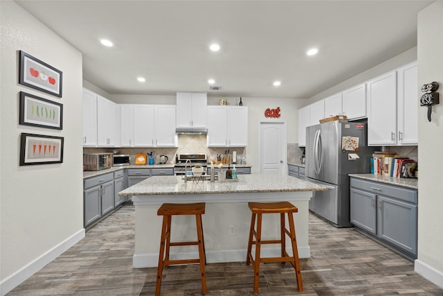 kitchen with gray cabinets, white cabinetry, a kitchen island with sink, and appliances with stainless steel finishes