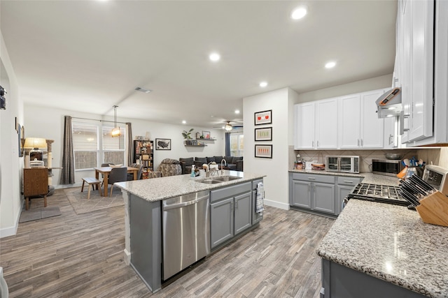 kitchen with ceiling fan, hanging light fixtures, stainless steel dishwasher, gray cabinets, and white cabinets