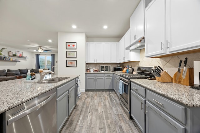 kitchen with white cabinets, sink, light hardwood / wood-style flooring, ceiling fan, and appliances with stainless steel finishes