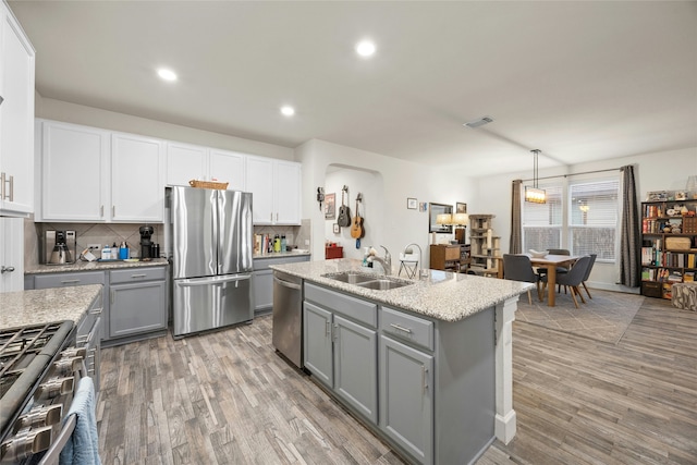 kitchen with white cabinets, appliances with stainless steel finishes, hanging light fixtures, and sink