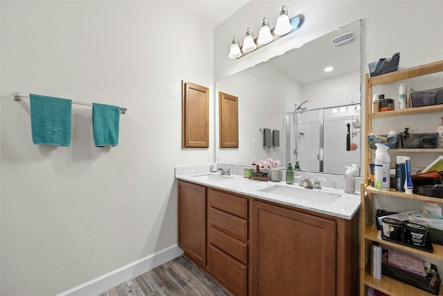 bathroom featuring walk in shower, vanity, and hardwood / wood-style flooring