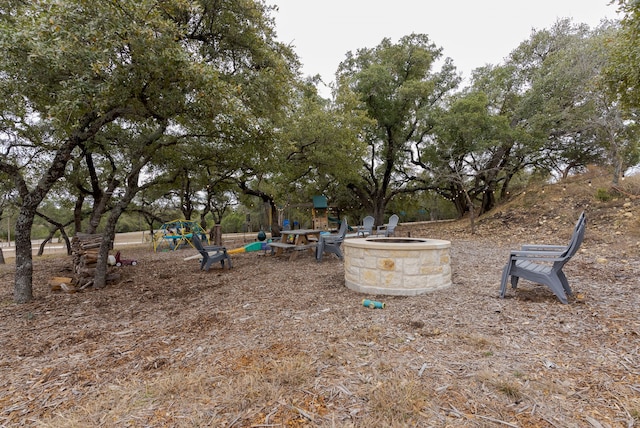 view of yard featuring a playground and a fire pit