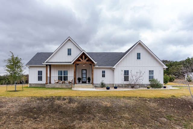 modern inspired farmhouse with a front lawn and a porch