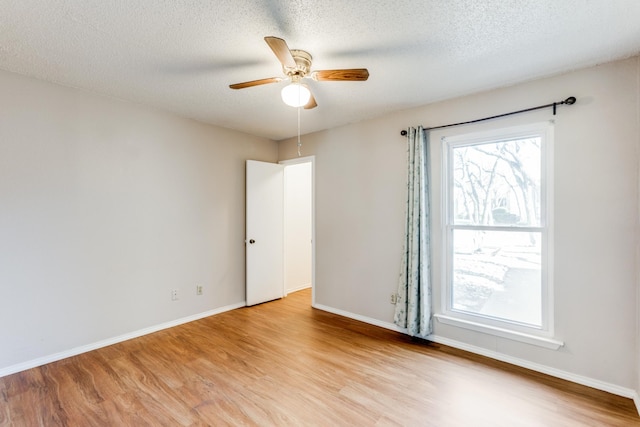 unfurnished room featuring a textured ceiling, ceiling fan, a healthy amount of sunlight, and light hardwood / wood-style floors