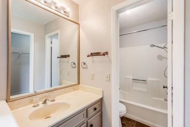 full bathroom with a textured ceiling, shower / bathing tub combination, tile patterned floors, vanity, and toilet