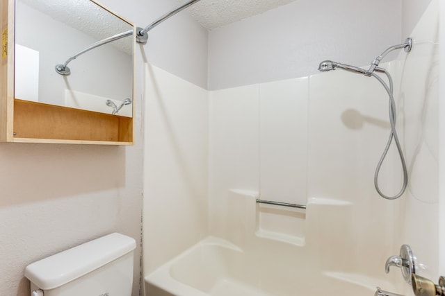 bathroom featuring bathtub / shower combination, a textured ceiling, and toilet