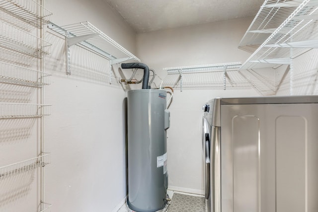 utility room featuring electric water heater and washing machine and clothes dryer