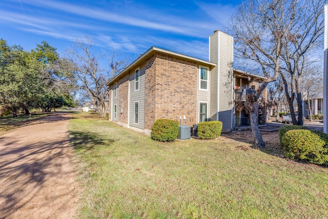 view of home's exterior featuring central AC unit and a lawn