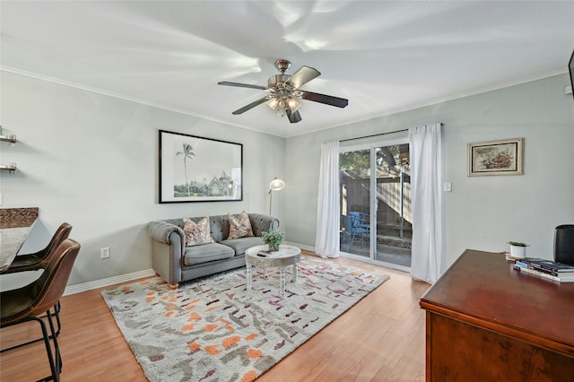 living room featuring ceiling fan, ornamental molding, and light hardwood / wood-style flooring