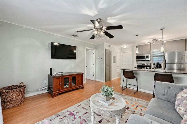 living room with ceiling fan, light hardwood / wood-style floors, ornamental molding, and sink