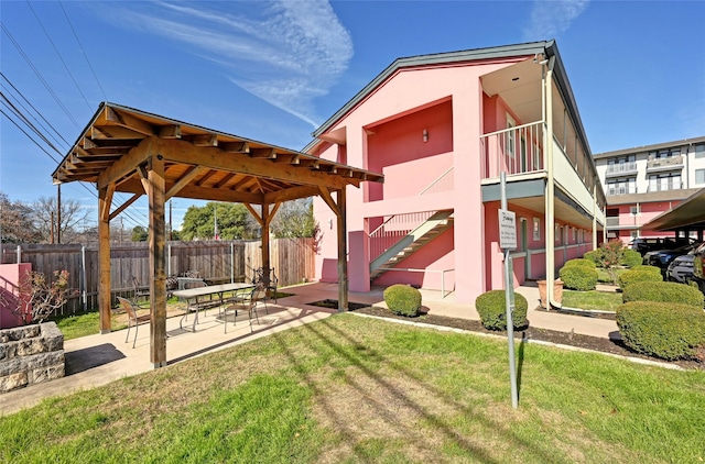 view of home's community featuring a lawn and a patio