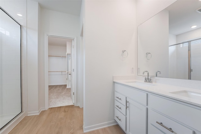 bathroom with a shower with door, vanity, and wood-type flooring