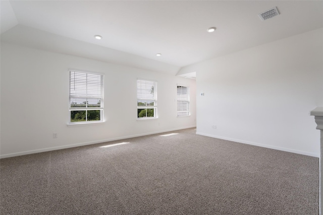 spare room featuring carpet flooring and vaulted ceiling