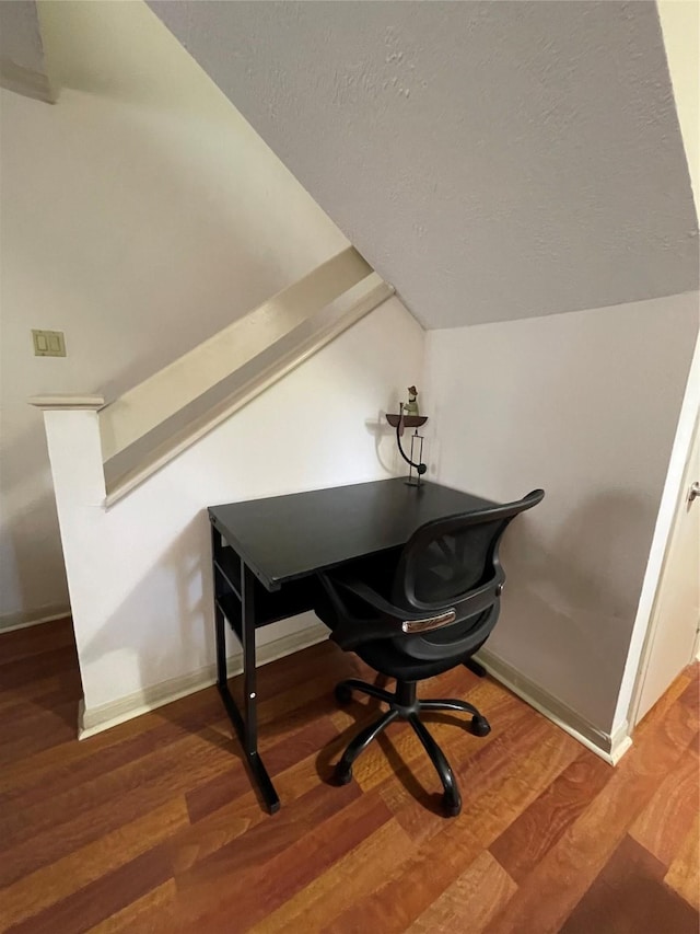 office area featuring lofted ceiling, wood-type flooring, and a textured ceiling