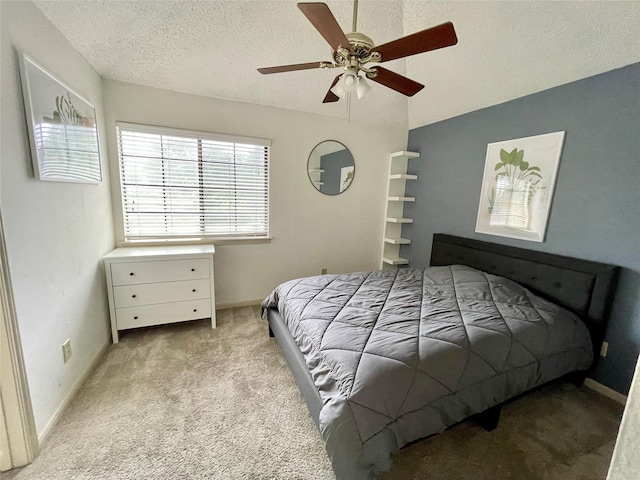 bedroom featuring ceiling fan, light carpet, and a textured ceiling