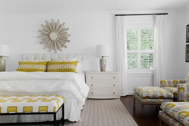 bedroom with wood finished floors and crown molding