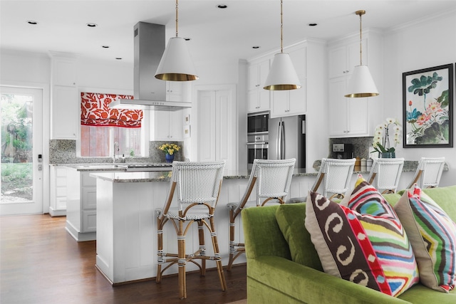 kitchen with appliances with stainless steel finishes, white cabinetry, and island range hood