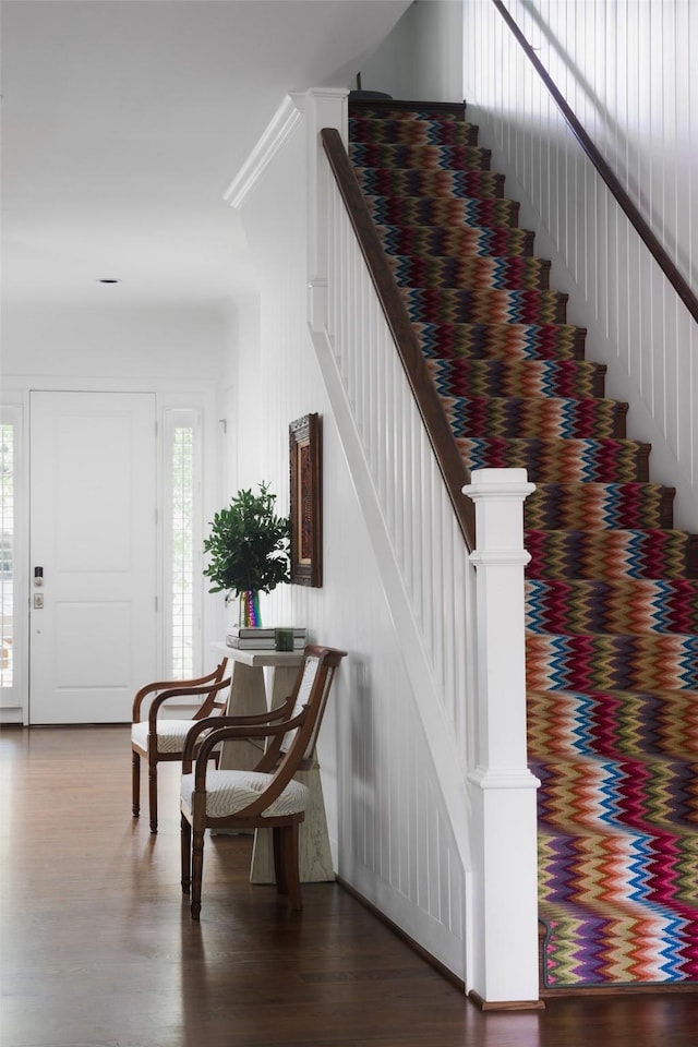 interior space featuring ornamental molding, stairway, and wood finished floors