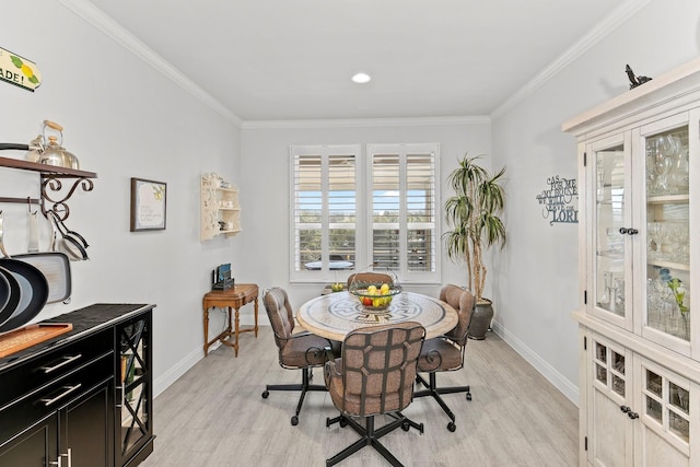 dining space with light wood-type flooring and crown molding