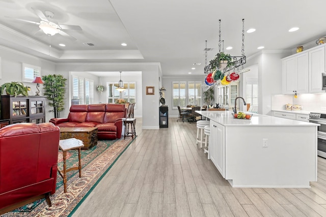 kitchen with white cabinetry, stainless steel appliances, an island with sink, and a kitchen bar