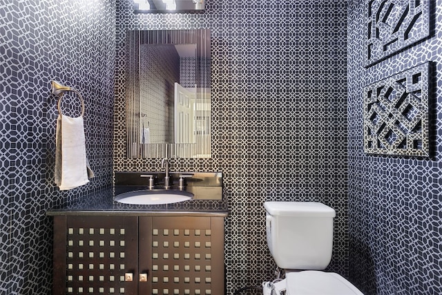 bathroom with tile walls, toilet, and vanity