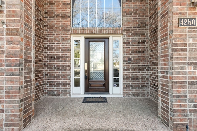 view of exterior entry with brick siding