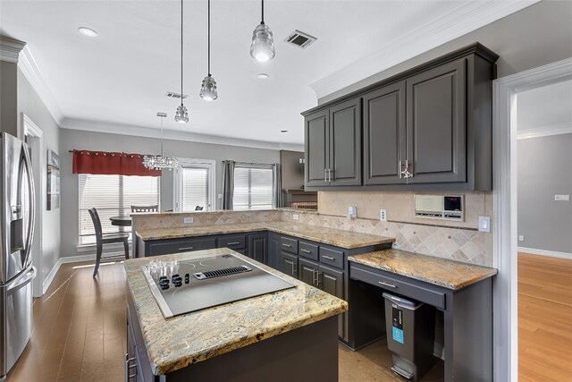 kitchen with a kitchen island, black electric stovetop, pendant lighting, and stainless steel refrigerator with ice dispenser