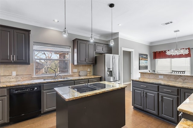 kitchen with crown molding, a sink, light stone countertops, black appliances, and pendant lighting