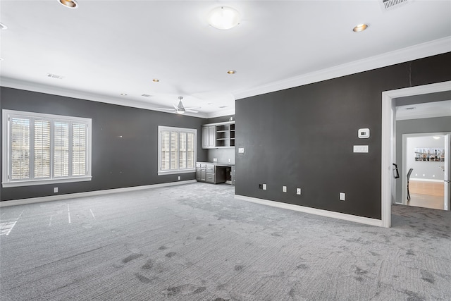 unfurnished living room with carpet, visible vents, crown molding, and baseboards