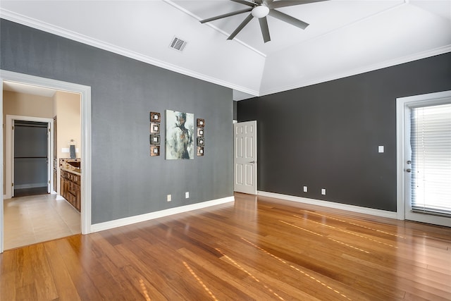 unfurnished room with visible vents, lofted ceiling, ceiling fan, ornamental molding, and wood finished floors