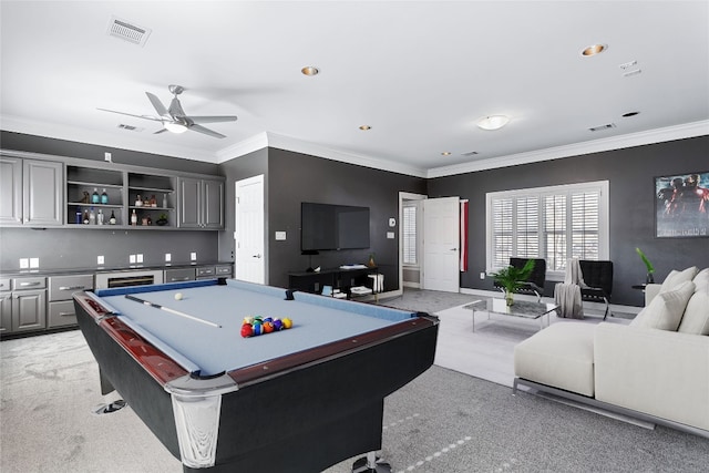 recreation room featuring crown molding, a ceiling fan, visible vents, and light colored carpet