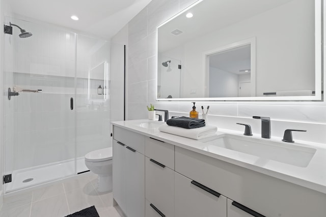 bathroom featuring tile walls, a shower with door, vanity, and toilet