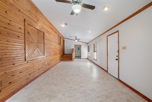 unfurnished room with ornamental molding, ceiling fan, and wooden walls