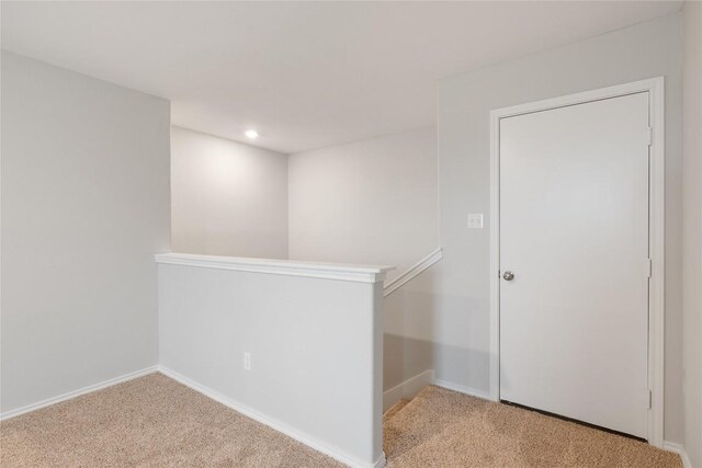 corridor featuring light colored carpet