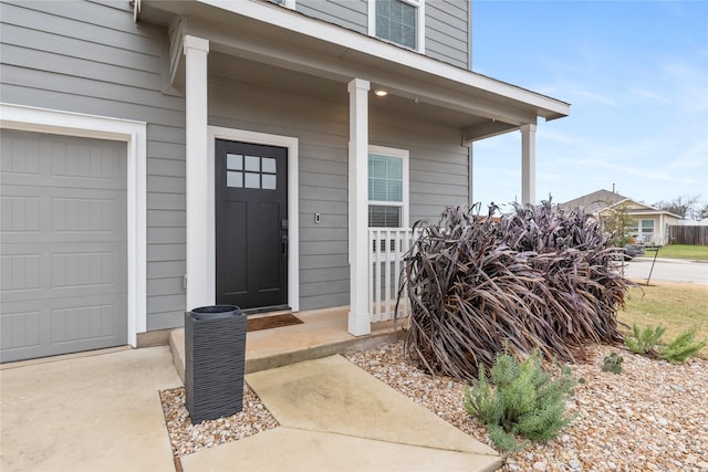 entrance to property with covered porch and a garage