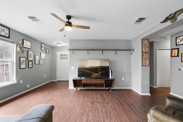 living room with dark hardwood / wood-style flooring and ceiling fan