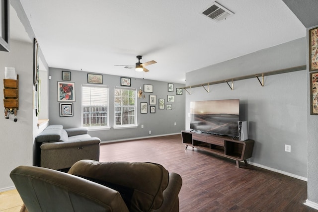 living room featuring ceiling fan and dark wood-type flooring