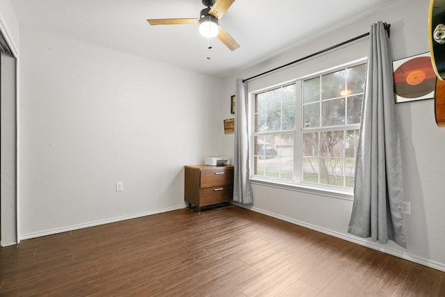 unfurnished bedroom with ceiling fan, dark hardwood / wood-style floors, and multiple windows