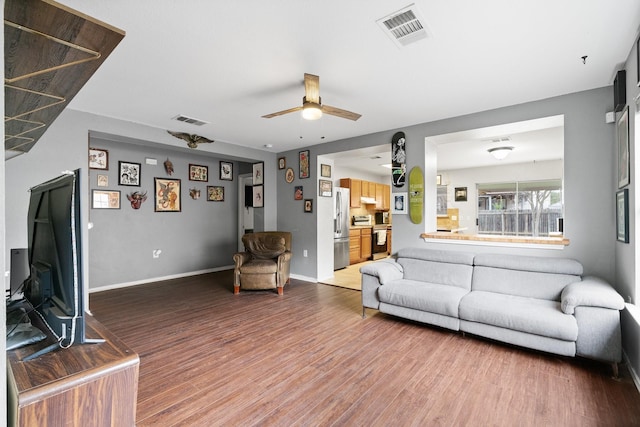 living room with ceiling fan and wood-type flooring