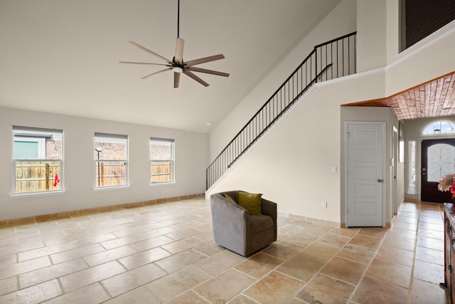 unfurnished living room with a healthy amount of sunlight, ceiling fan, and high vaulted ceiling