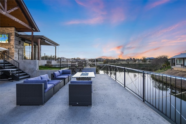 patio terrace at dusk featuring an outdoor living space with a fire pit