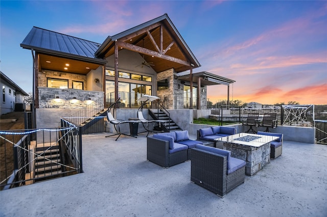 patio terrace at dusk featuring an outdoor fire pit and ceiling fan