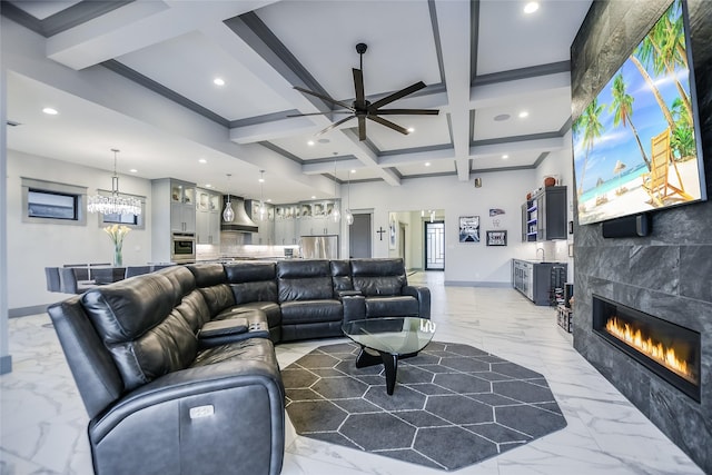 living room with coffered ceiling, a tiled fireplace, ceiling fan, and beam ceiling