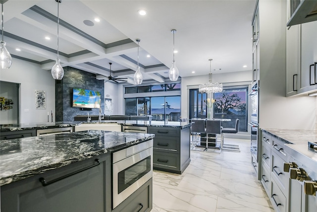 kitchen with dark stone counters, stainless steel appliances, and decorative light fixtures