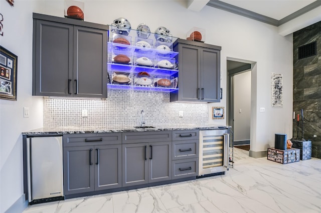 kitchen featuring beverage cooler, gray cabinets, light stone countertops, and stainless steel refrigerator