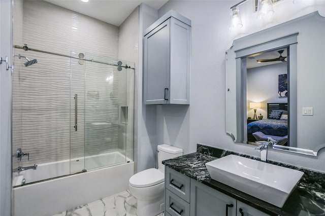 full bathroom with ceiling fan, enclosed tub / shower combo, vanity, and toilet