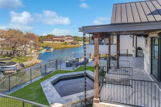 view of dock featuring a jacuzzi, a patio, a water view, and a lawn