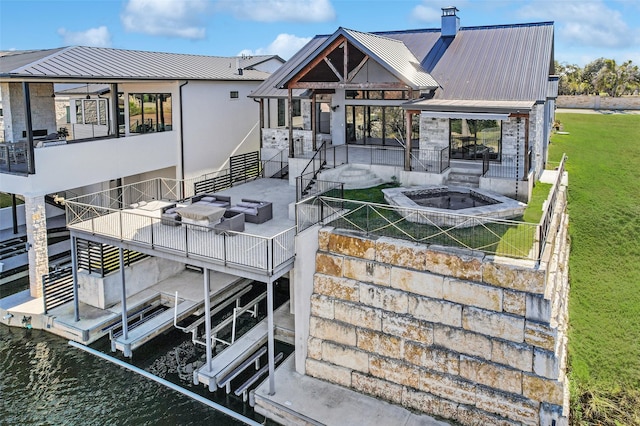 rear view of house with a lawn, a balcony, a water view, a patio area, and an outdoor living space